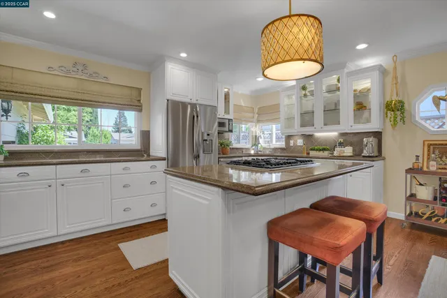 a kitchen with stainless steel appliances granite countertop a sink a stove and a refrigerator