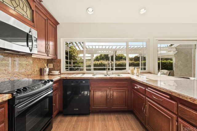 a kitchen with a sink stove top oven and cabinets