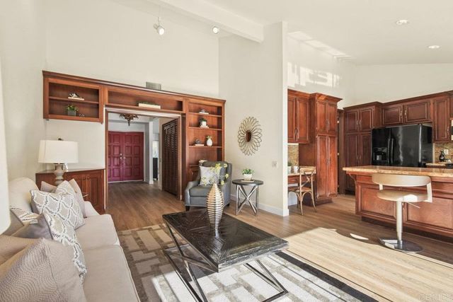 a living room with furniture a wooden floor and next to a window
