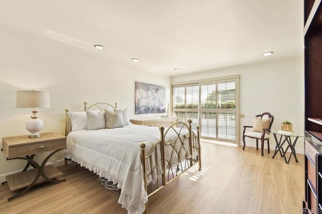 a bedroom with a large bed and a flat tv screen on dresser