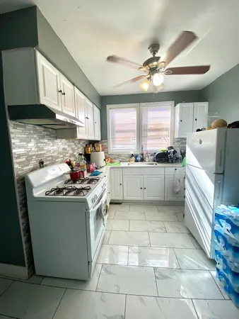 a kitchen with a stove sink and cabinets