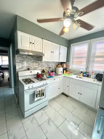 a kitchen with a stove sink and cabinets