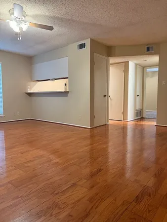 a view of an empty room with wooden floor
