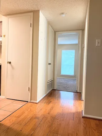 an empty room with wooden floor and a window