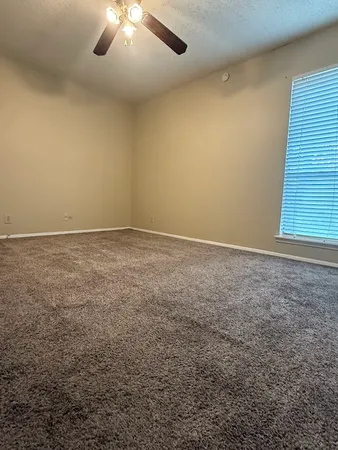 an empty room with a chandelier fan