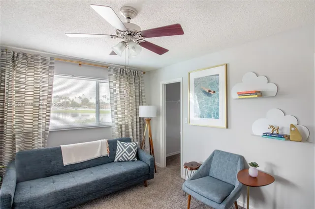 a living room with furniture a flat screen tv and a large window