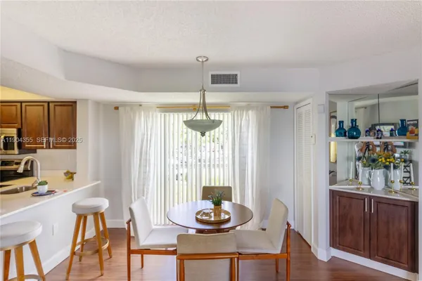 a living room with furniture a dining table and a large window