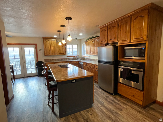 333 Lago Liberty Road Grace, ID 83241 - Photo 26 of 35 Kitchen featuring stainless steel appliances, wood finish cabinetry, a kitchen island, french doors, and a kitchen bar