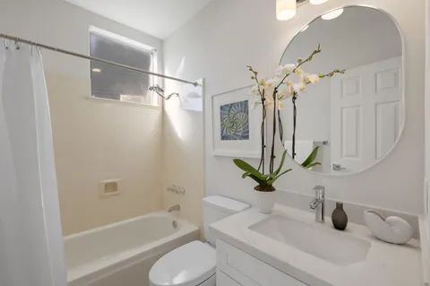 a bathroom with a granite countertop sink a toilet and bathtub