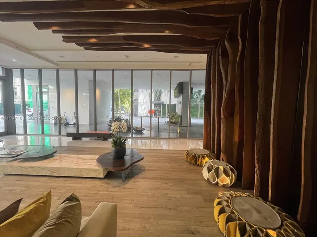 a living room with furniture and floor to ceiling windows