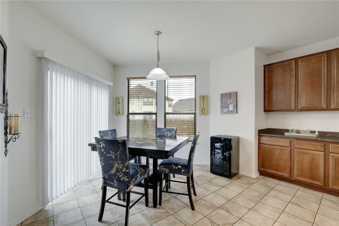 356 Matthews Kyle, TX 78640 - Photo 2 of 30 A casual dining area features a tile floor, a classic pendant light, and a convenient wine cooler.