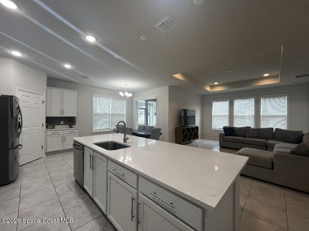 2359 Bonnyton Lane Palm Bay, FL 32907 - Photo 5 of 15 a living room with stainless steel appliances kitchen island granite countertop a sink and white cabinets