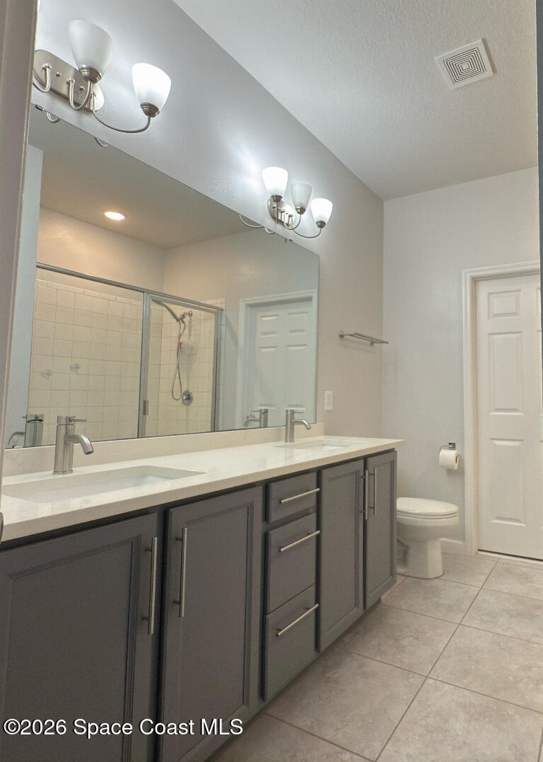 2359 Bonnyton Lane Palm Bay, FL 32907 - Photo 7 of 15 a spacious bathroom with a double vanity sink a toilet and a mirror