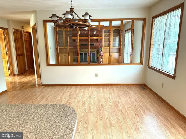 view of an empty room with wooden floor and a window