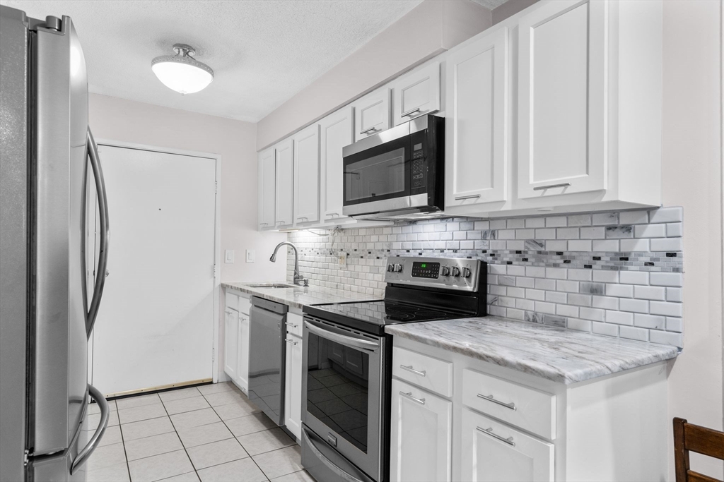 3 Dailey Street, Unit B Attleboro, MA 02703 - Photo 11 of 30 a kitchen with stainless steel appliances granite countertop a stove a refrigerator and a microwave