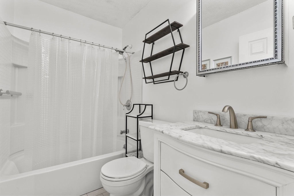 3 Dailey Street, Unit B Attleboro, MA 02703 - Photo 20 of 30 a bathroom with a granite countertop sink a toilet and a bathtub