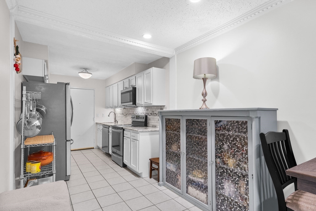 3 Dailey Street, Unit B Attleboro, MA 02703 - Photo 10 of 30 a kitchen with stainless steel appliances granite countertop a stove a sink and a refrigerator