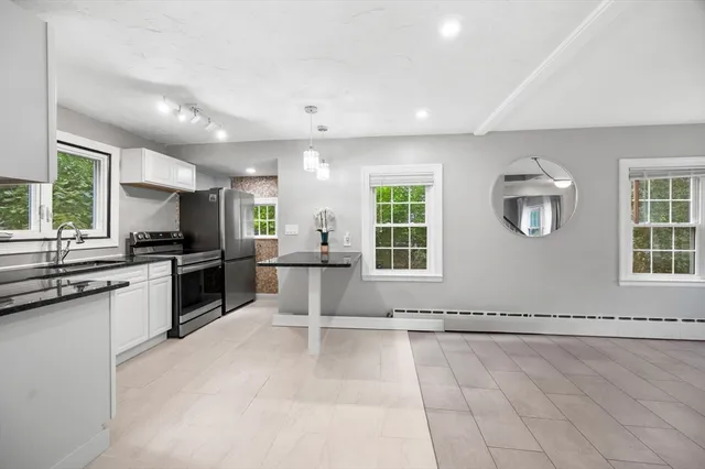 a kitchen with granite countertop a stove a sink and a refrigerator