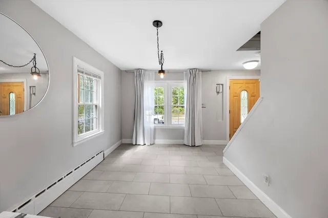 a view of an empty room with window and cabinet