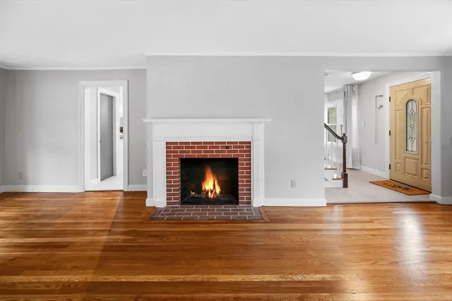 a view of empty room with wooden floor and fireplace