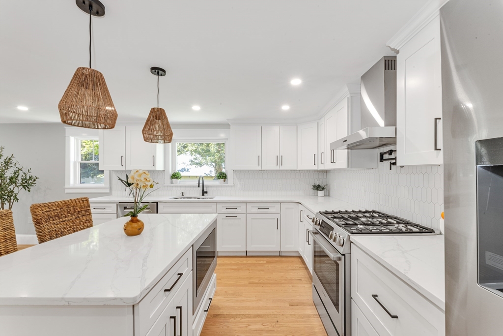 180 Dent Street Boston, MA 02132 - Photo 11 of 30 a kitchen with stainless steel appliances a sink a stove a refrigerator and white cabinets