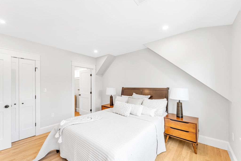 180 Dent Street Boston, MA 02132 - Photo 13 of 30 a bedroom with a bed and wooden floor