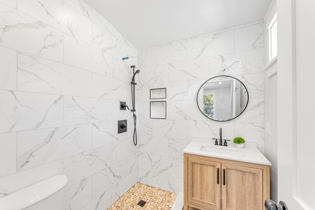 180 Dent Street Boston, MA 02132 - Photo 14 of 30 a bathroom with a sink a mirror and bathtub