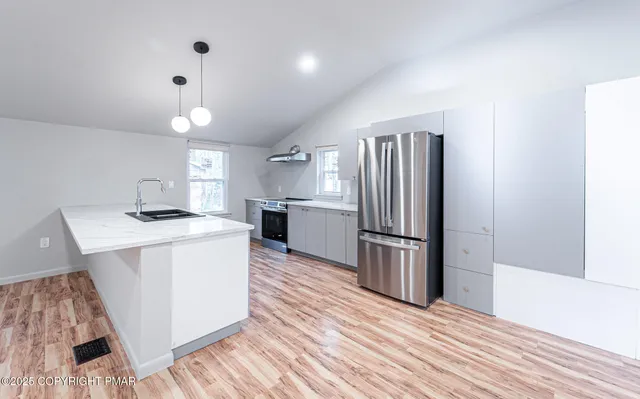 a kitchen with kitchen island a sink and a refrigerator