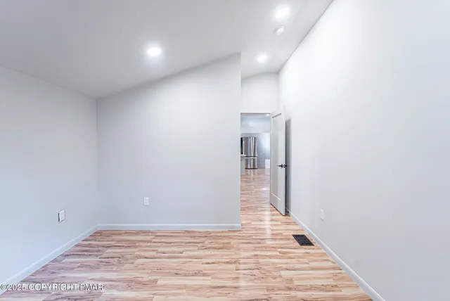 a view of a hallway with wooden floor