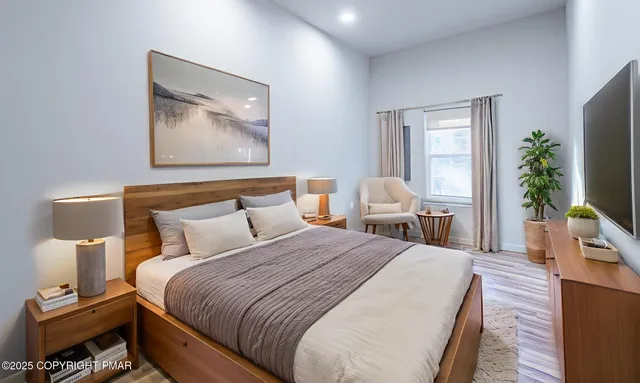 a bedroom with a bed and wooden floor