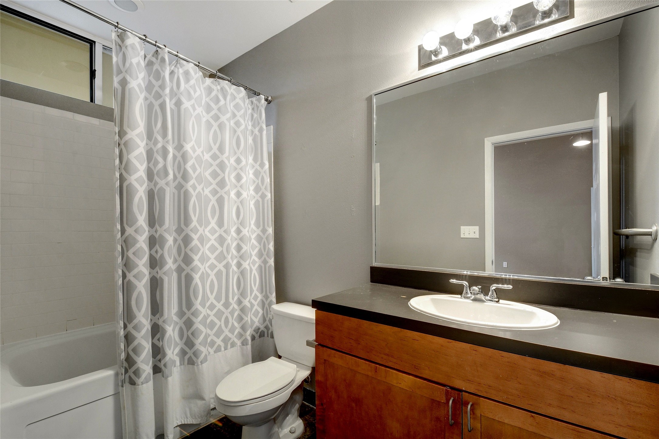 2401 East 6th Street, Unit 41 Austin, TX 78702 - Photo 16 of 23 a bathroom with a sink a toilet and a mirror