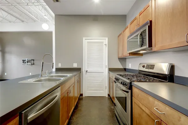 a view of a kitchen with a sink and a refrigerator