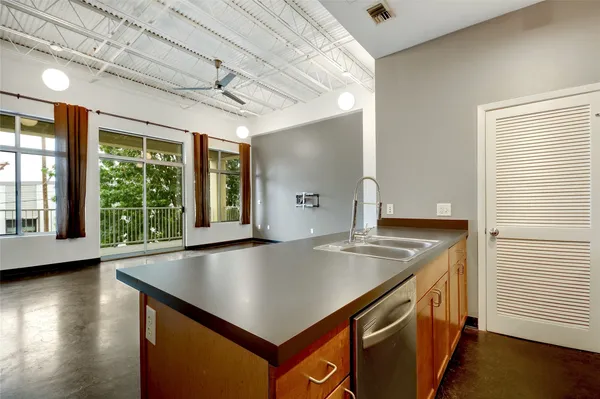 a kitchen with stainless steel appliances granite countertop a refrigerator a sink a stove a microwave a counter space and cabinets