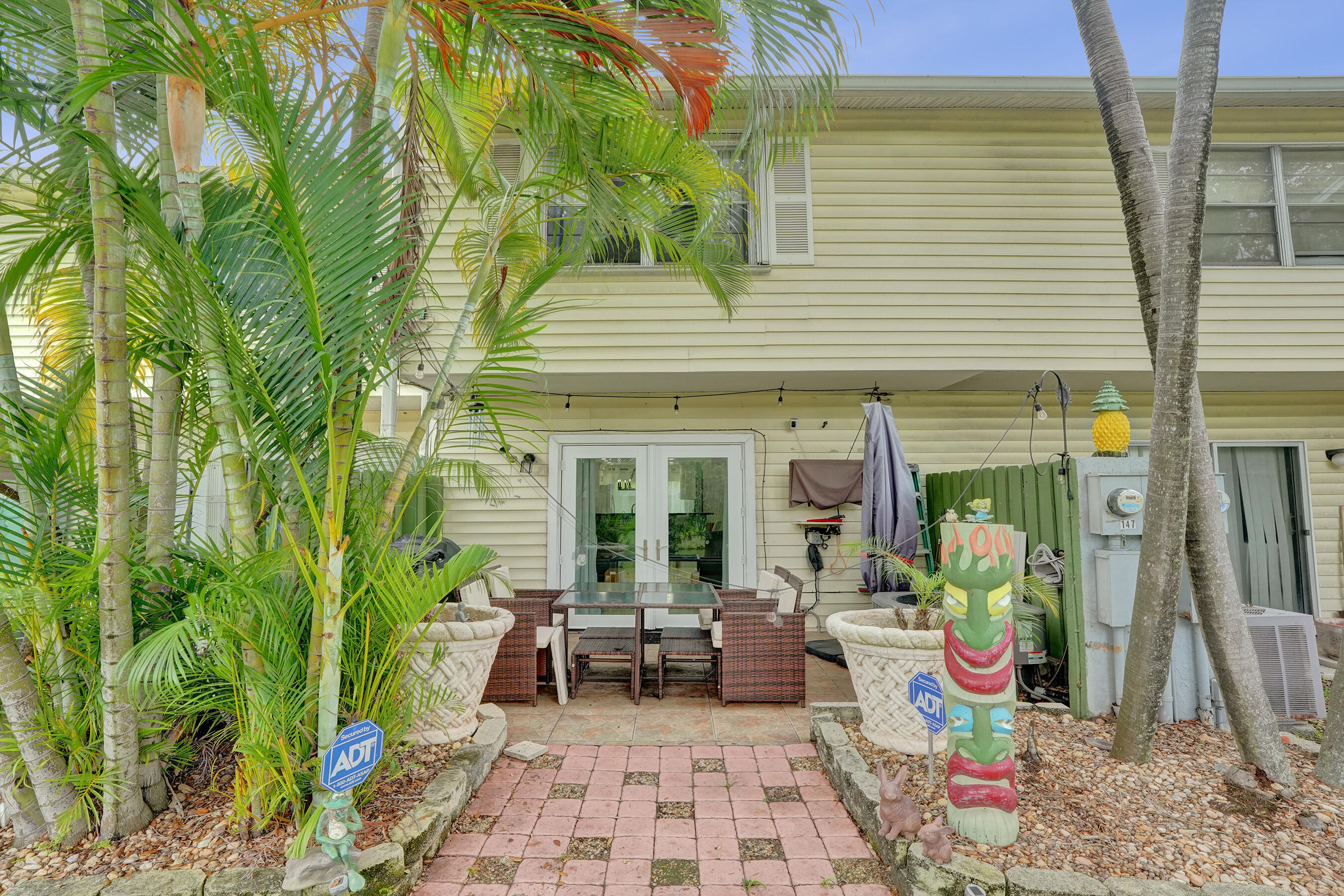 147 Southwest 3rd Street Pompano Beach, FL 33060 - Photo 3 of 29 a view of a patio with table and chairs potted plants and floor to ceiling window