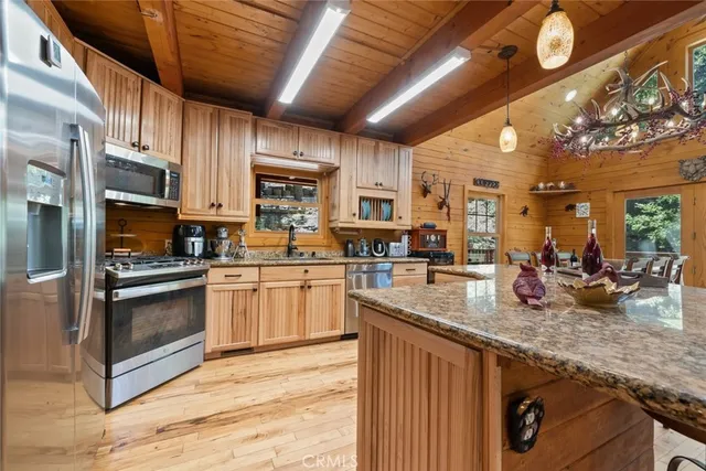 a kitchen with stainless steel appliances granite countertop a refrigerator and a stove top oven
