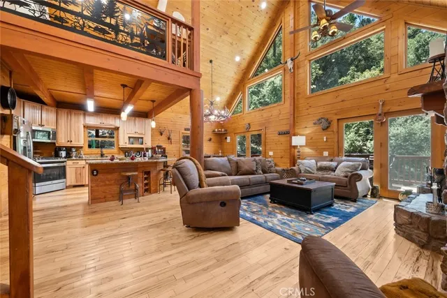 a living room with stainless steel appliances kitchen island granite countertop wooden floors and a large window