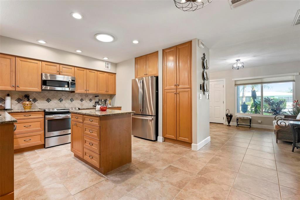 104 Alba Street West Venice, FL 34285 - Photo 15 of 42 a kitchen with stainless steel appliances granite countertop a refrigerator stove and sink