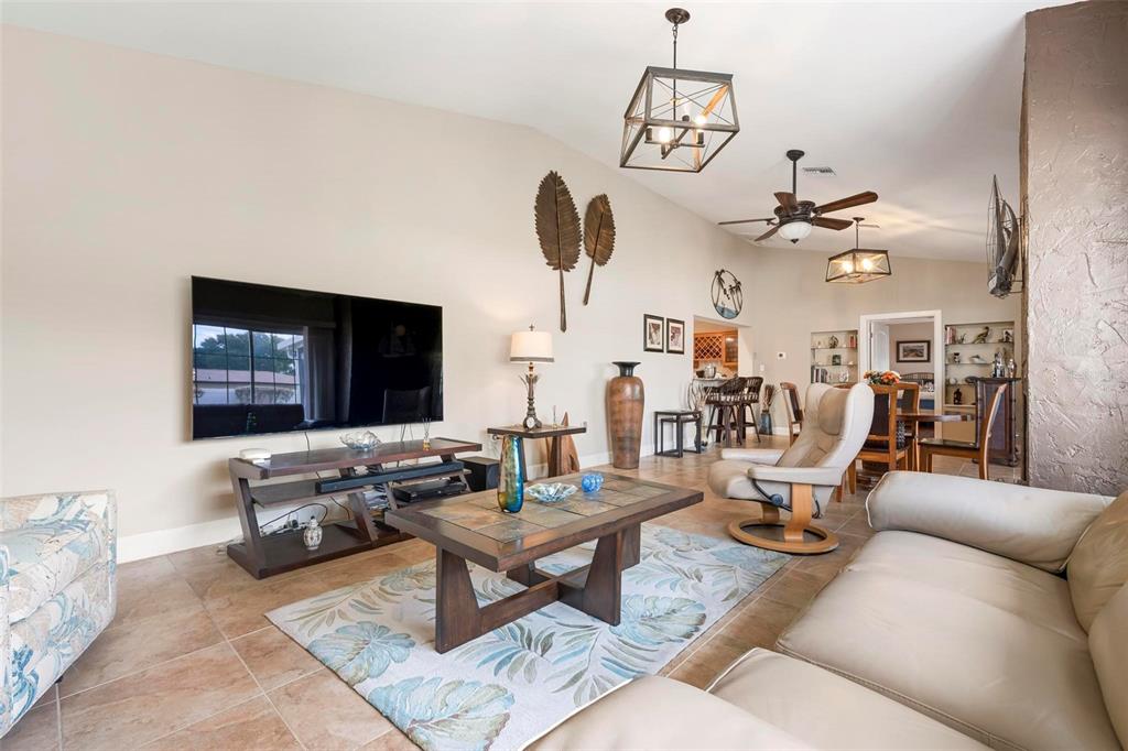 104 Alba Street West Venice, FL 34285 - Photo 5 of 42 a living room with furniture a chandelier and a flat screen tv
