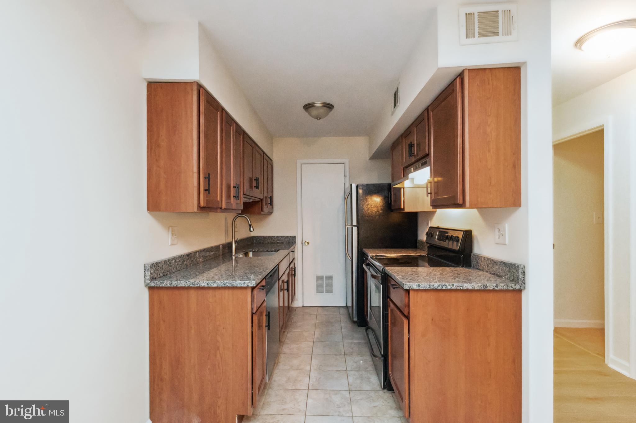 8312 Kingsgate Road, Unit 534 Springfield, VA 22152 - Photo 14 of 32 a kitchen with stainless steel appliances granite countertop a sink stove and refrigerator