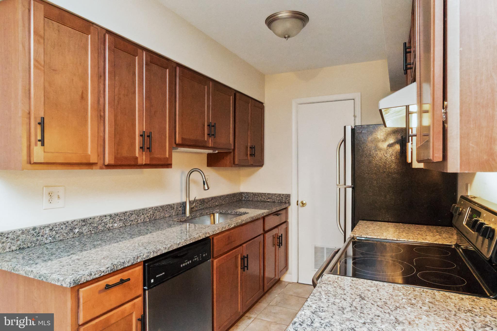 8312 Kingsgate Road, Unit 534 Springfield, VA 22152 - Photo 15 of 32 a kitchen with stainless steel appliances granite countertop a sink stove and refrigerator