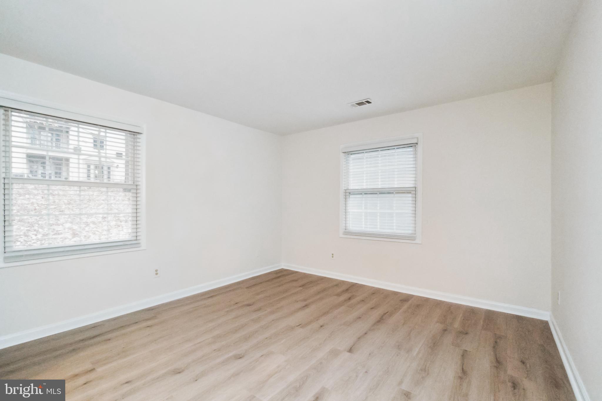 8312 Kingsgate Road, Unit 534 Springfield, VA 22152 - Photo 17 of 32 an empty room with wooden floor and windows