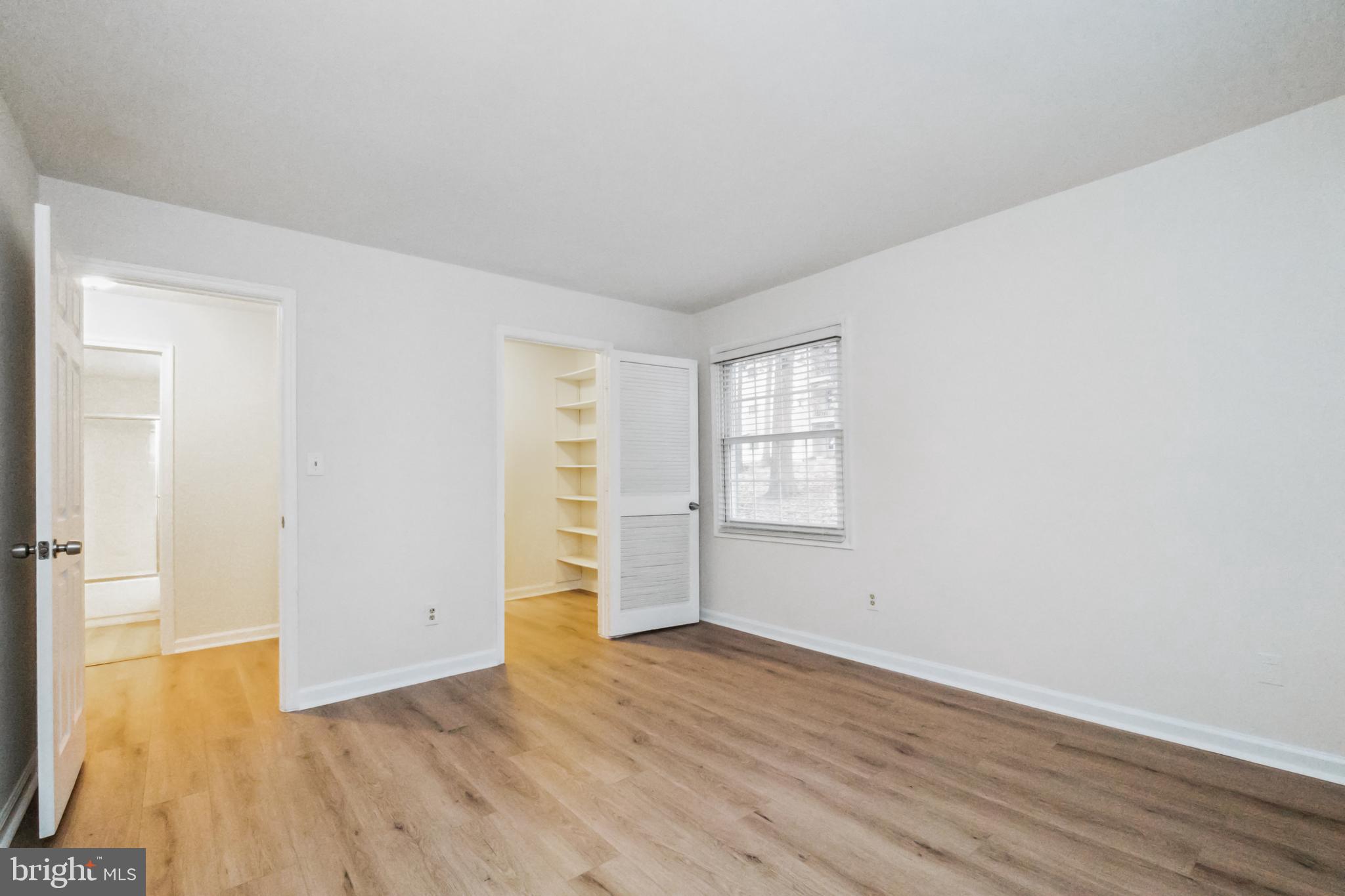8312 Kingsgate Road, Unit 534 Springfield, VA 22152 - Photo 18 of 32 an empty room with wooden floor and windows