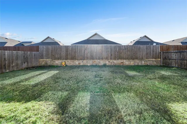 a view of a backyard with wooden fence