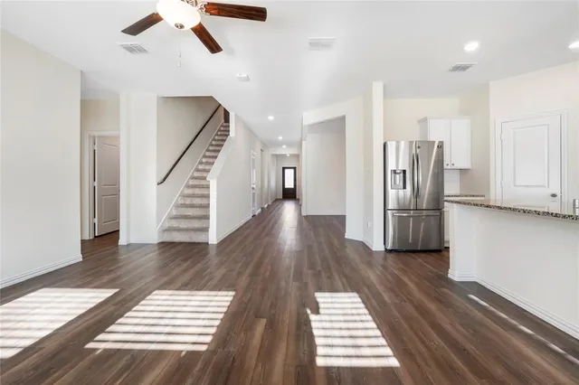 a view of a hallway with wooden floor and staircase