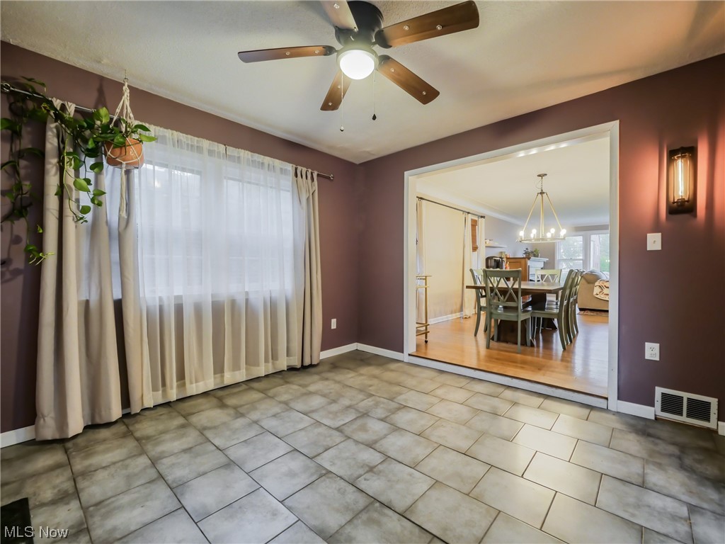 2378 Charney Road Cleveland, OH 44118 - Photo 8 of 28 Tiled empty room with ceiling fan with notable chandelier
