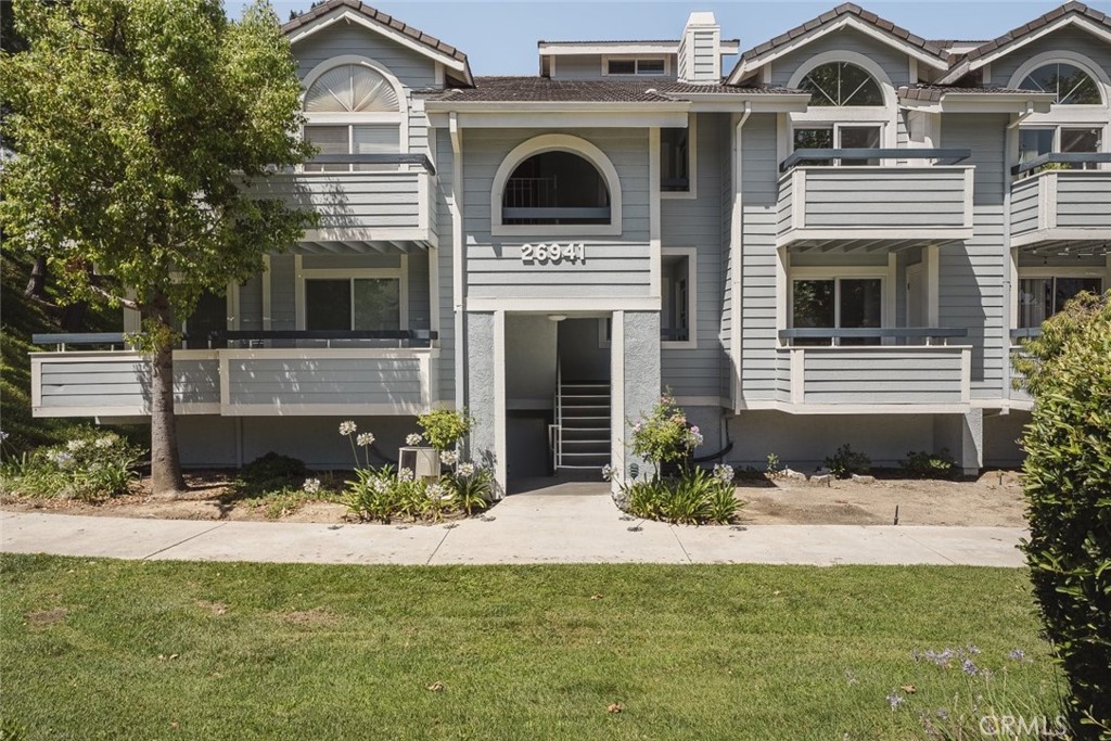 26941 Rainbow Glen Drive, Unit 751 Santa Clarita, CA 91351 - Photo 1 of 34 a front view of a house with a yard and garage