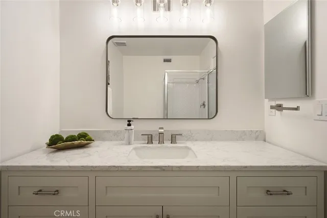 a bathroom with a sink vanity and a mirror