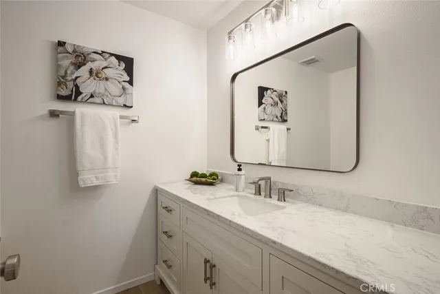 a bathroom with a sink vanity and a mirror