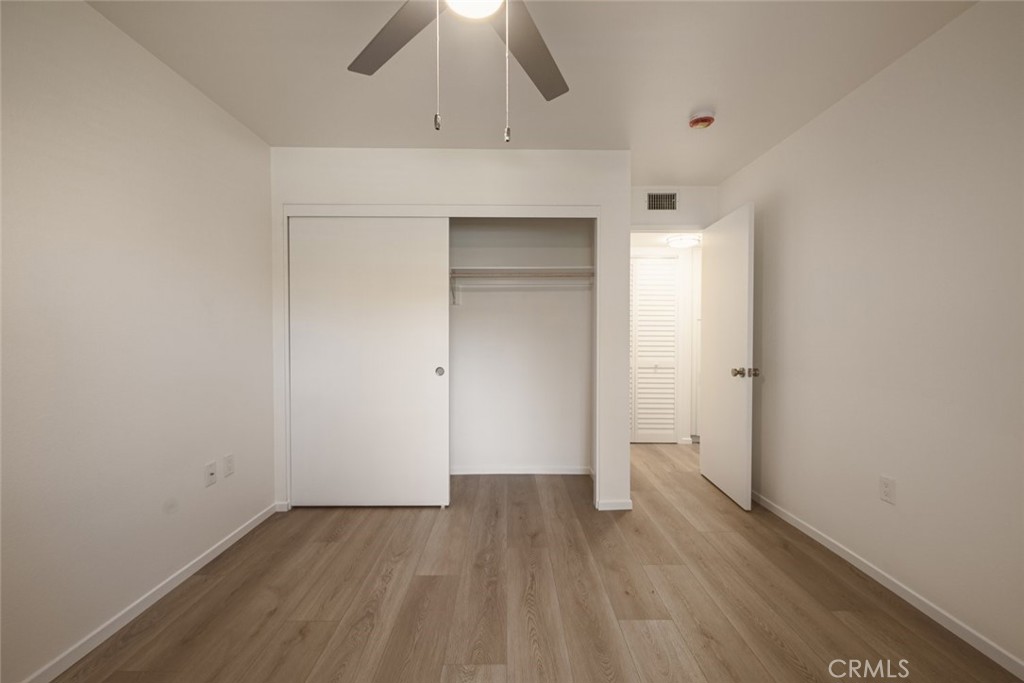 26941 Rainbow Glen Drive, Unit 751 Santa Clarita, CA 91351 - Photo 19 of 34 an empty room with wooden floor fan and windows