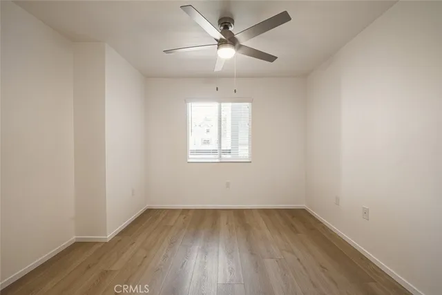 an empty room with a window and wooden floor